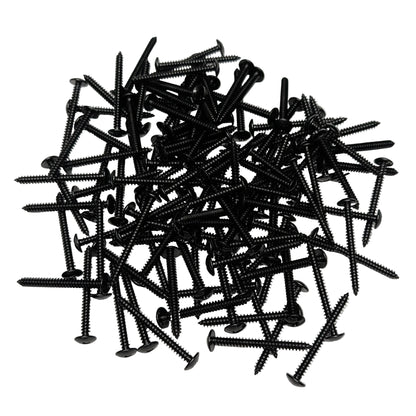 A pile of black 2" truss-head wood screws, scattered on a white background.