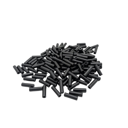 A pile of 150 black cylindrical spacers scattered on a plain white background.