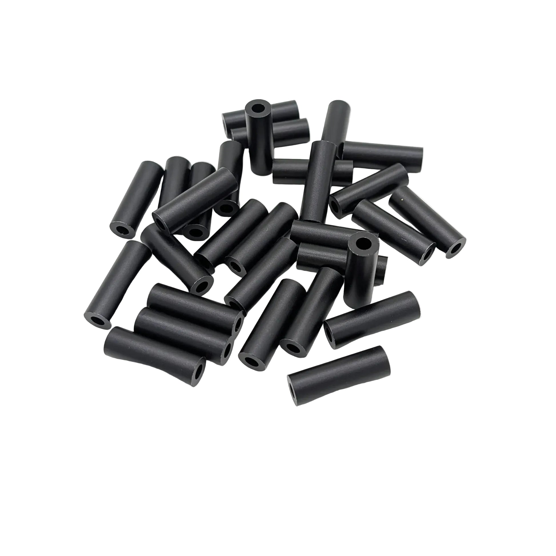 A pile of black cylindrical spacers with hollow centers, photographed on a plain white background.