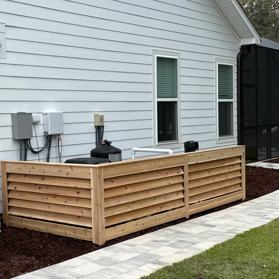 Louvered panels surrounding equipment next to a home.