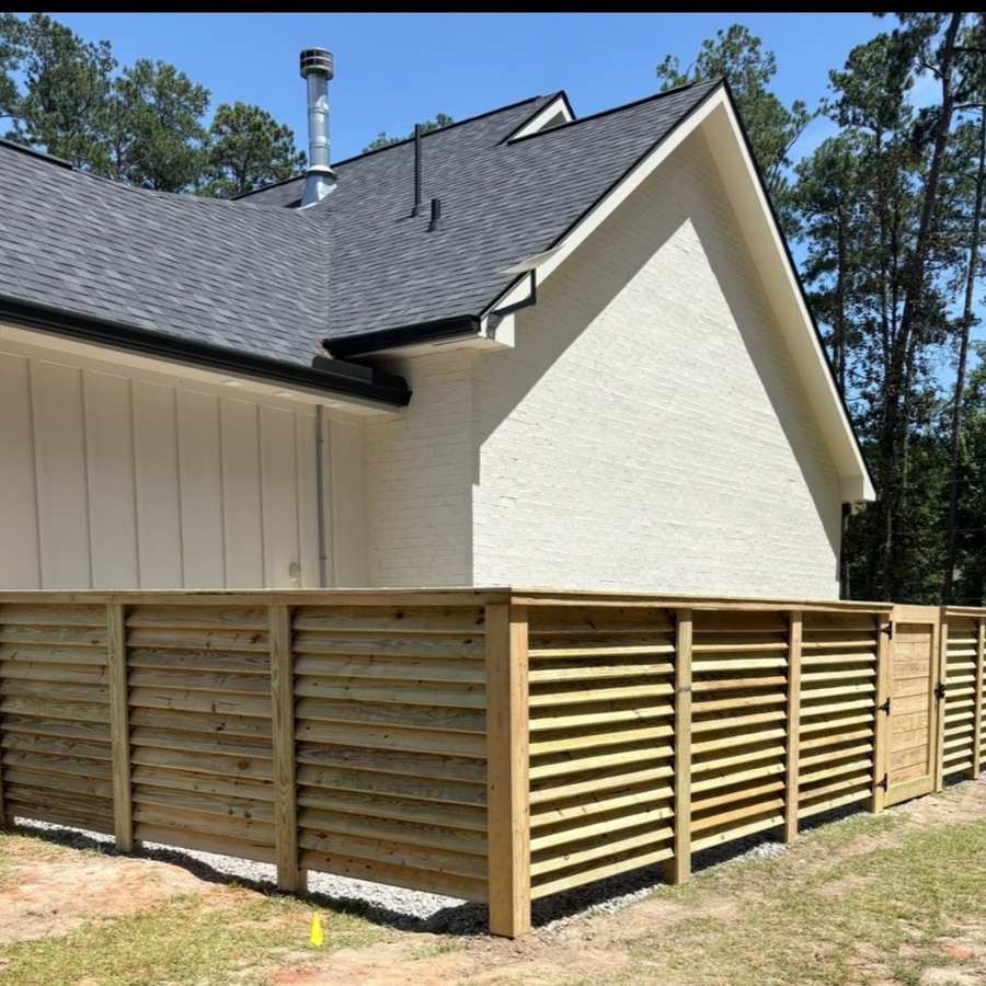 Wooden horizontal louvered fenced enclosure with a gate, about 5 feet tall.