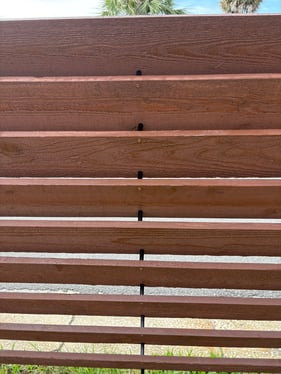 Close-up of EZ Louver Spacers installed between wood slats to prevent warping and twisting.