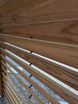 Detailed view of louvered slats with spacers maintaining perfectly aligned gaps for airflow.